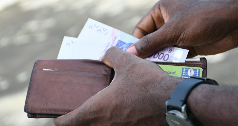 a person holding a pen and a paper with writing on it